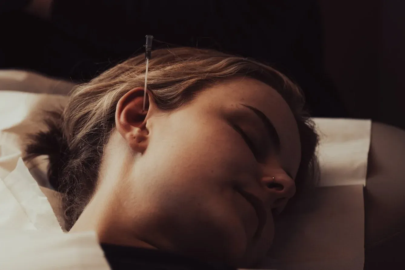 Client having ear pierced with needle method